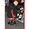 Un homme est assis sur un tabouret rouge à roulettes et travaille sur un appareil. Il porte des vêtements noirs.